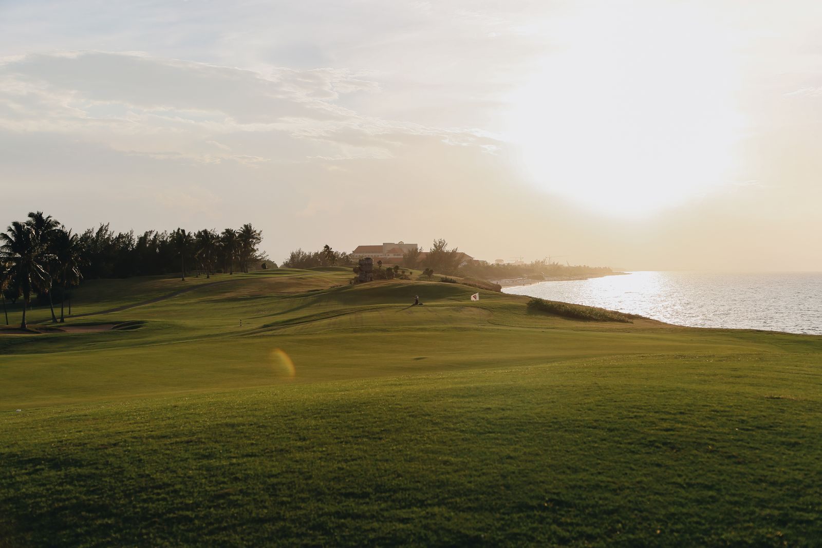 Low evening sun over a coastal golf course with the ocean beside it